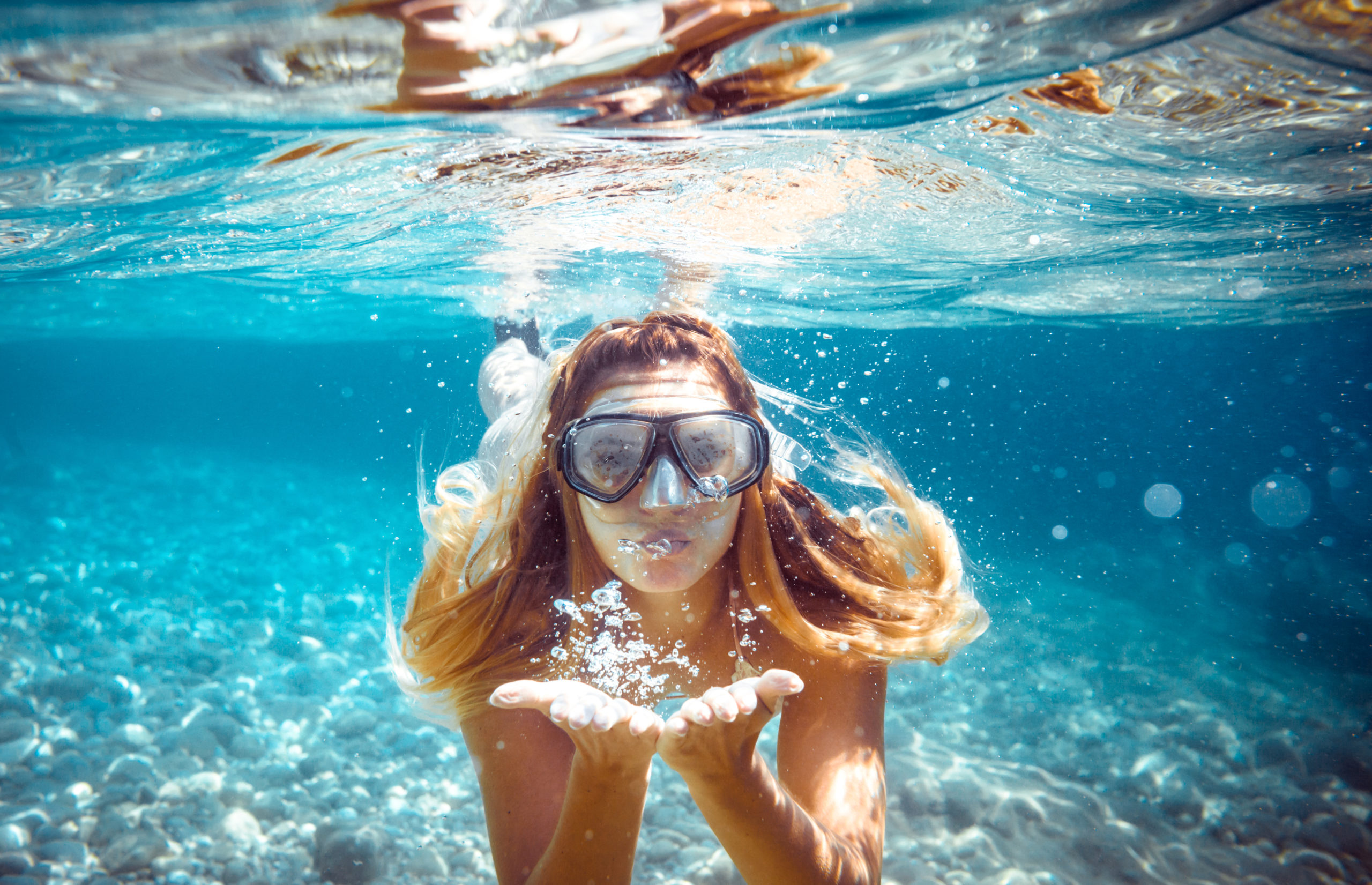 Tauchende Frau unter Wasser im Ozean