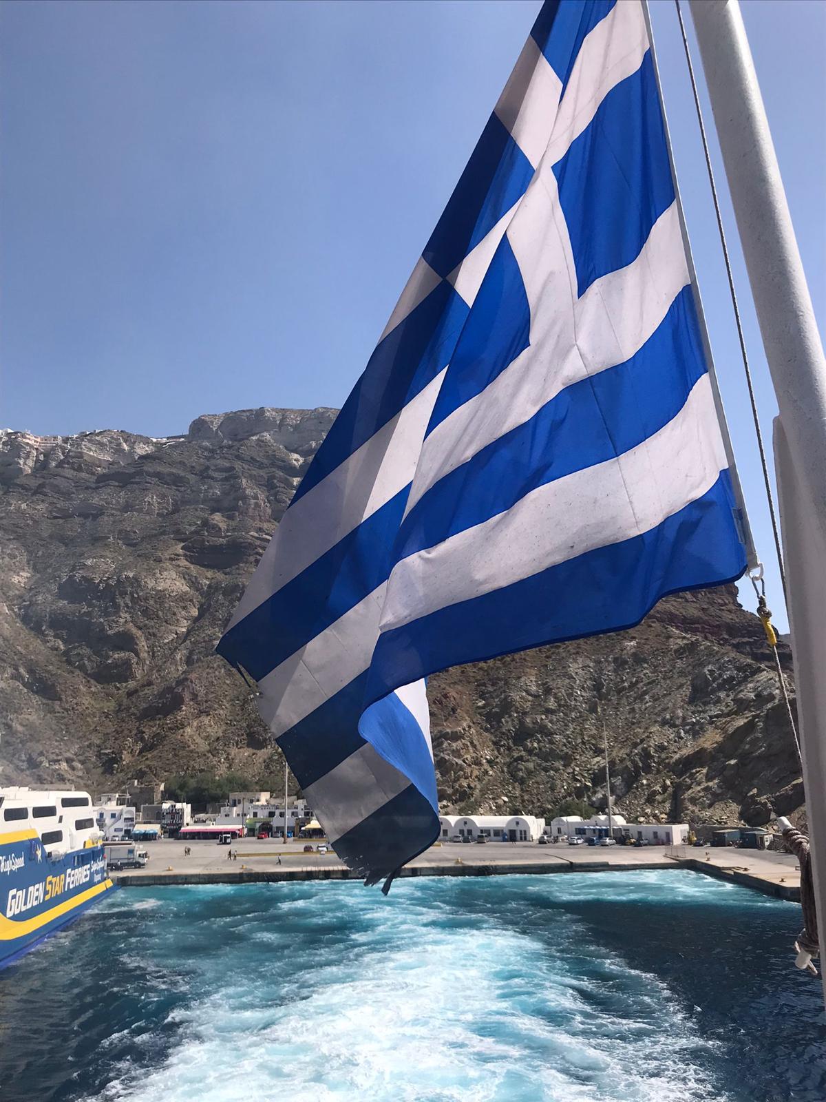 Einfahrt mit der Fähre i den Hafen von Naxos mit wehender Flagge