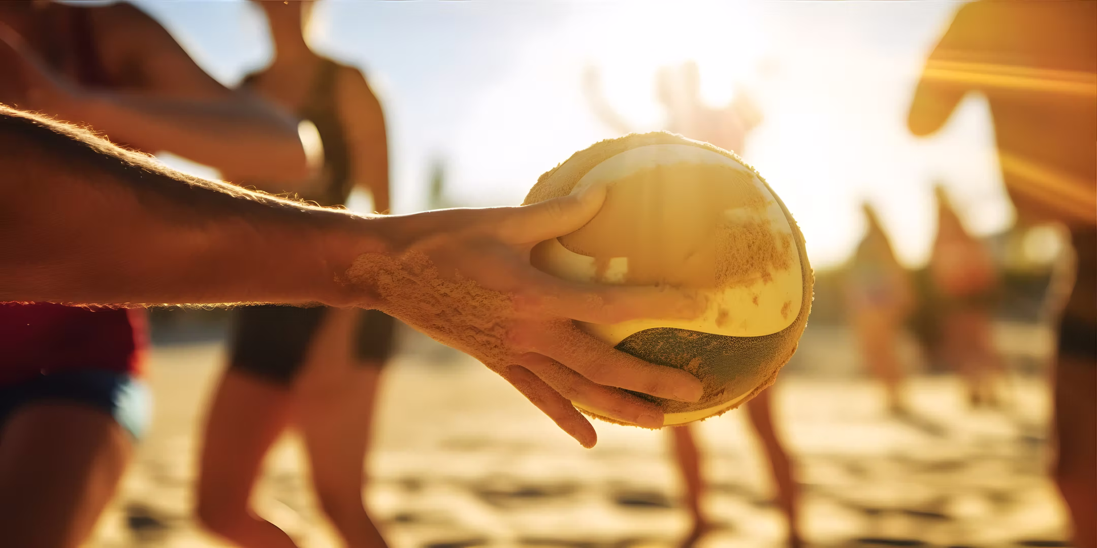 Handball der am Strand in der Hand eines Sportlers liegt